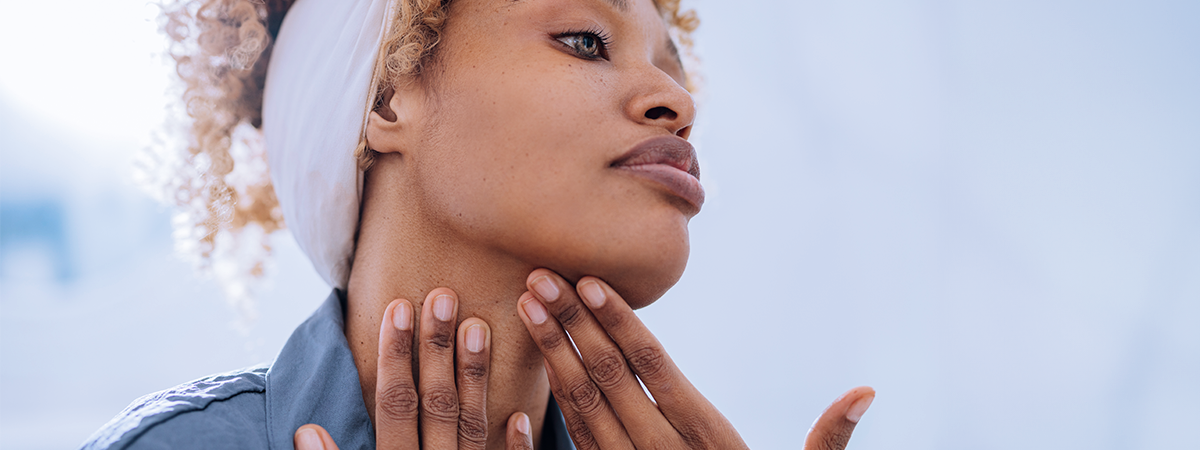Mulher negra fazendo auto-massagem na mandíbula