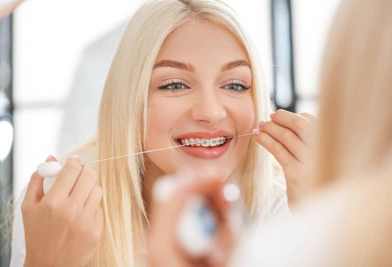 Usar o fio dental para dentes com aparelho é imprescindível para ter uma boa rotina de higiene bucal durante o tratamento ortodôntico